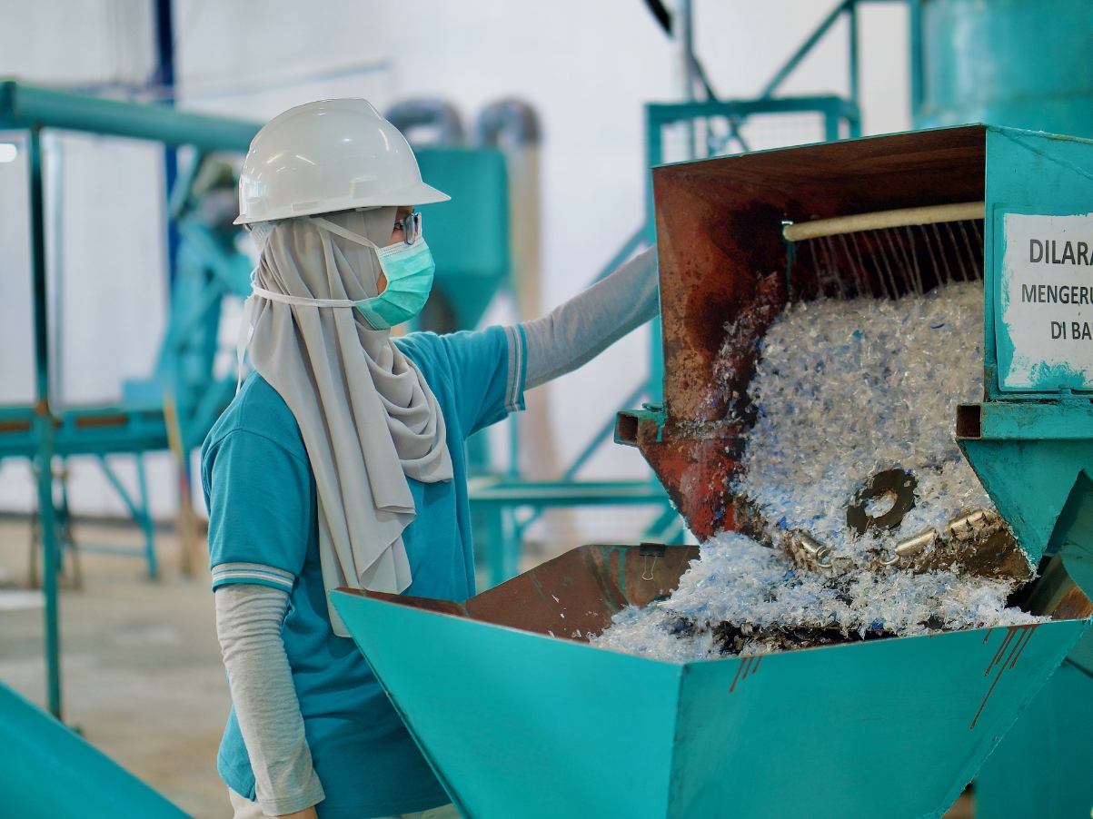 Photograph of a woman working with recycled plastic bottles
